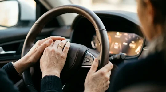 Conducteur vérifiant son compteur kilométrique avec satisfaction pour économiser sur son assurance auto